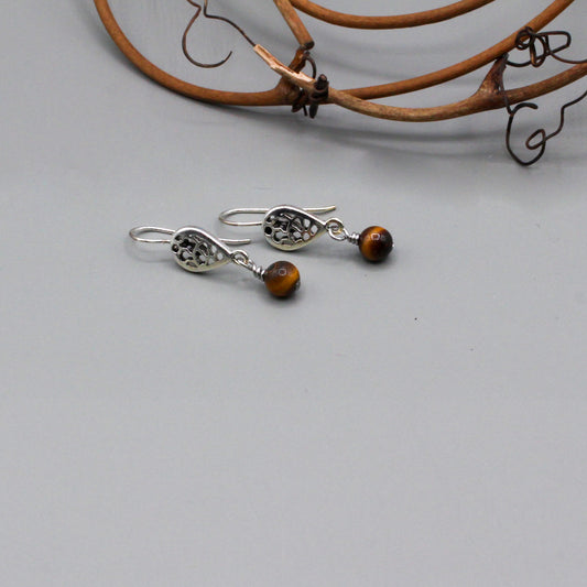 Tiger eye gemstone that gracefully moves from a delicate filigree fish-hook ear-wire. They present a harmonious blend of vivid color and intricate metalwork.