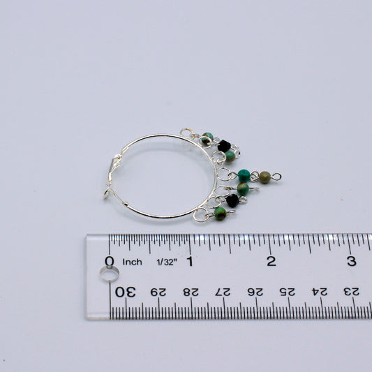 These hoop earrings feature a 1 1/2"" diameter and are crafted with African Turquoise stones. They incorporate silver electroplated metals.