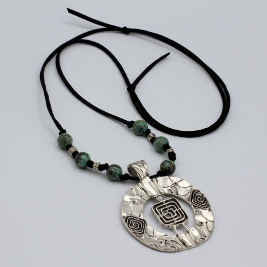 This necklace offers adjustable length from 20" to 32" and features African Turquoise beads complemented by a pewter focal piece and spacers, all strung on soft suede for a sophisticated look.